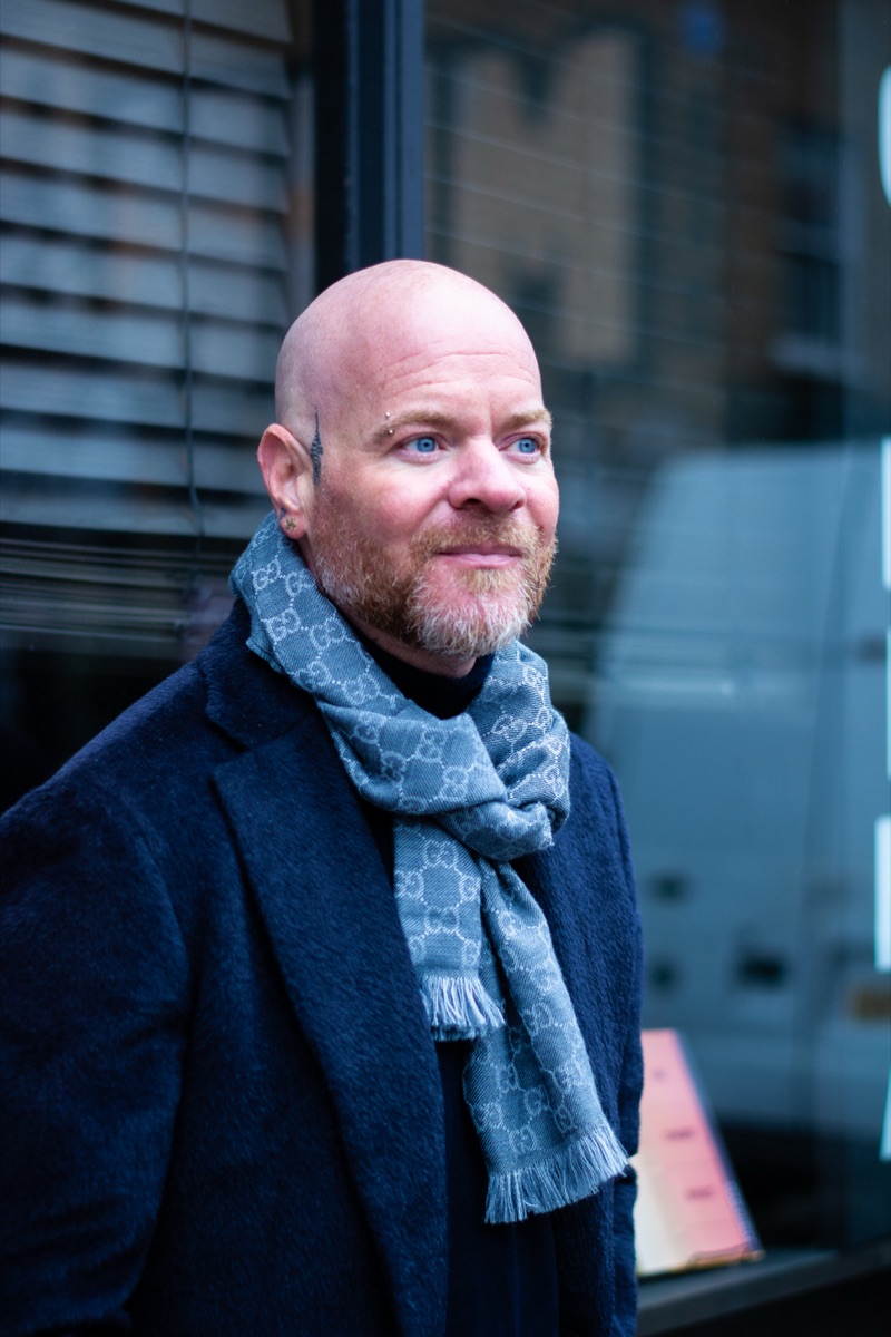 Carl Reader, Gucci scarf, navy coat, window blinds